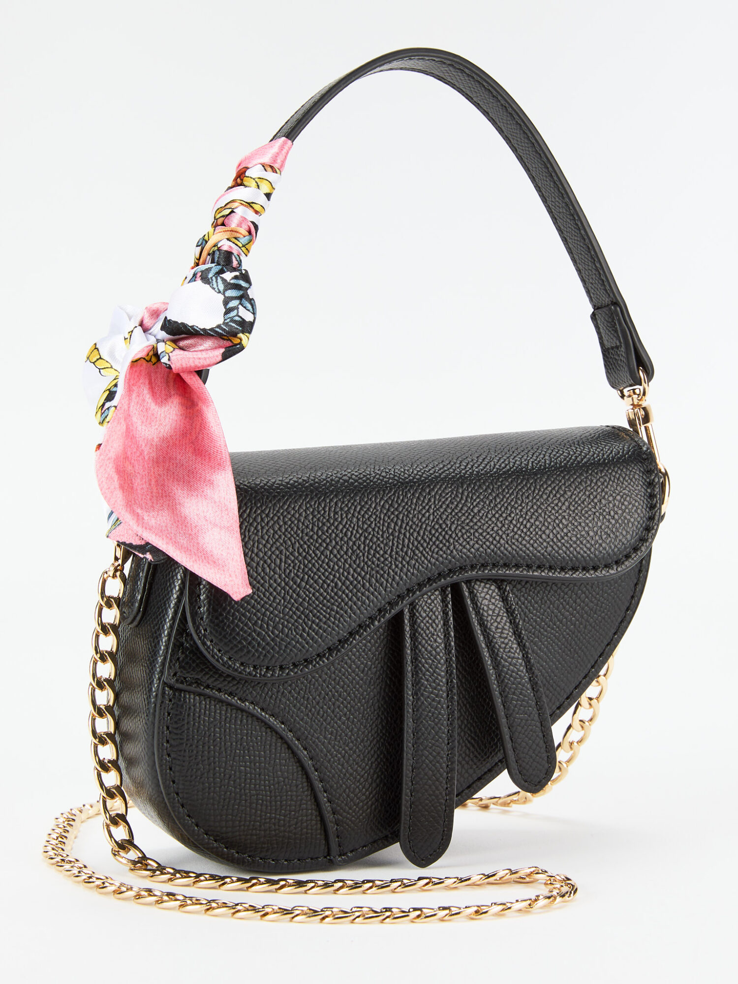 Black handbag with a gold chain strap and a pink silk scarf tied to the handle, against a white background.