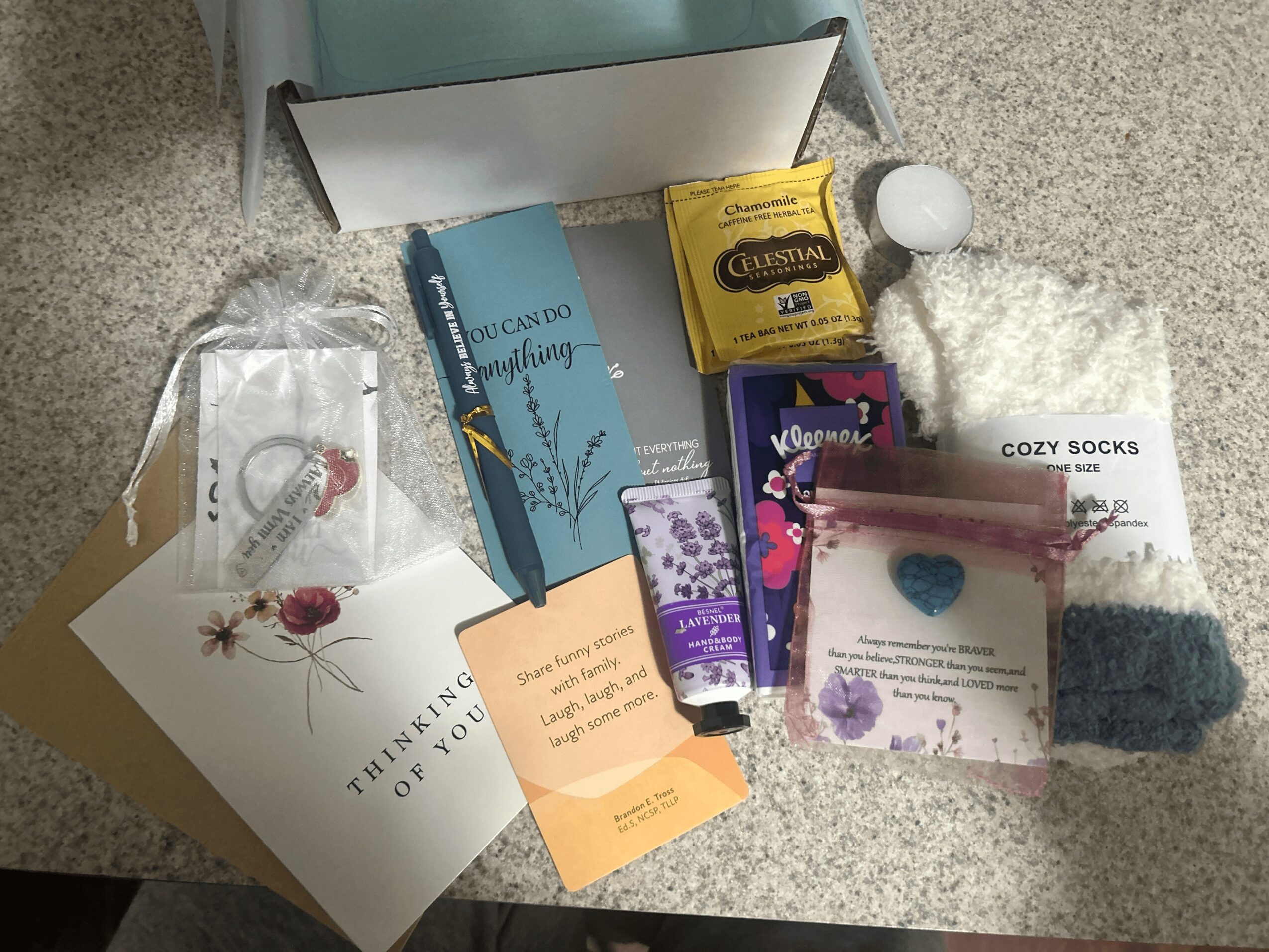 Various gift items including socks, chocolates, a book, and small accessories on a countertop.