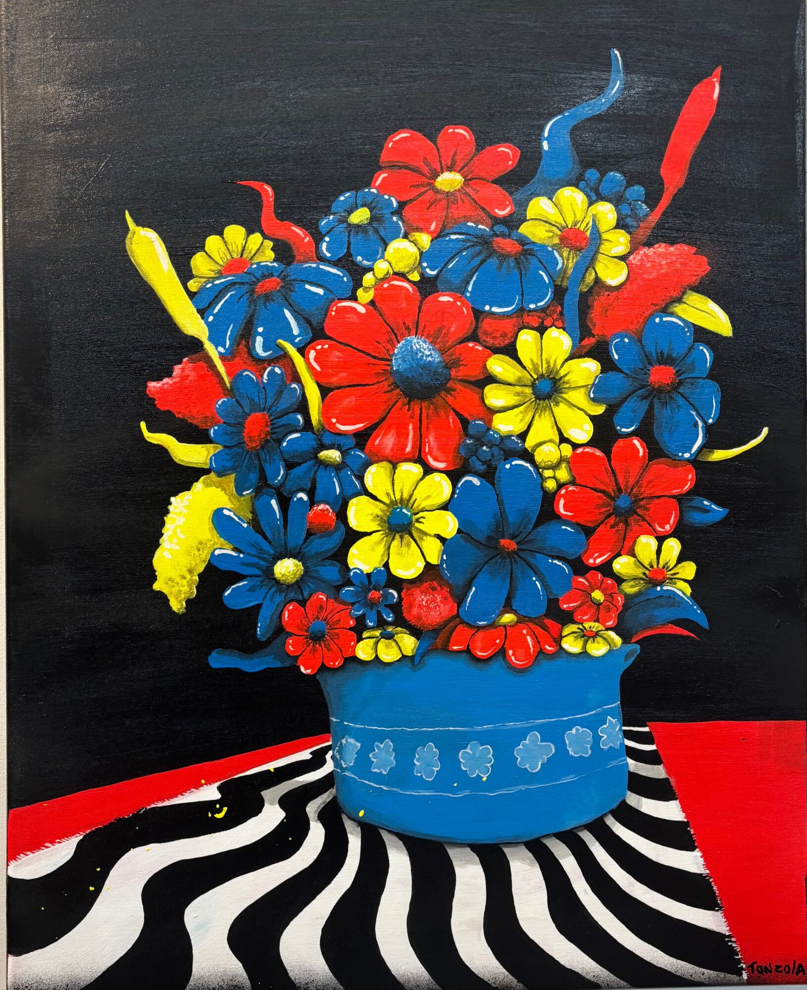 Brightly colored flowers in a blue vase on a black and white striped surface with a red background.