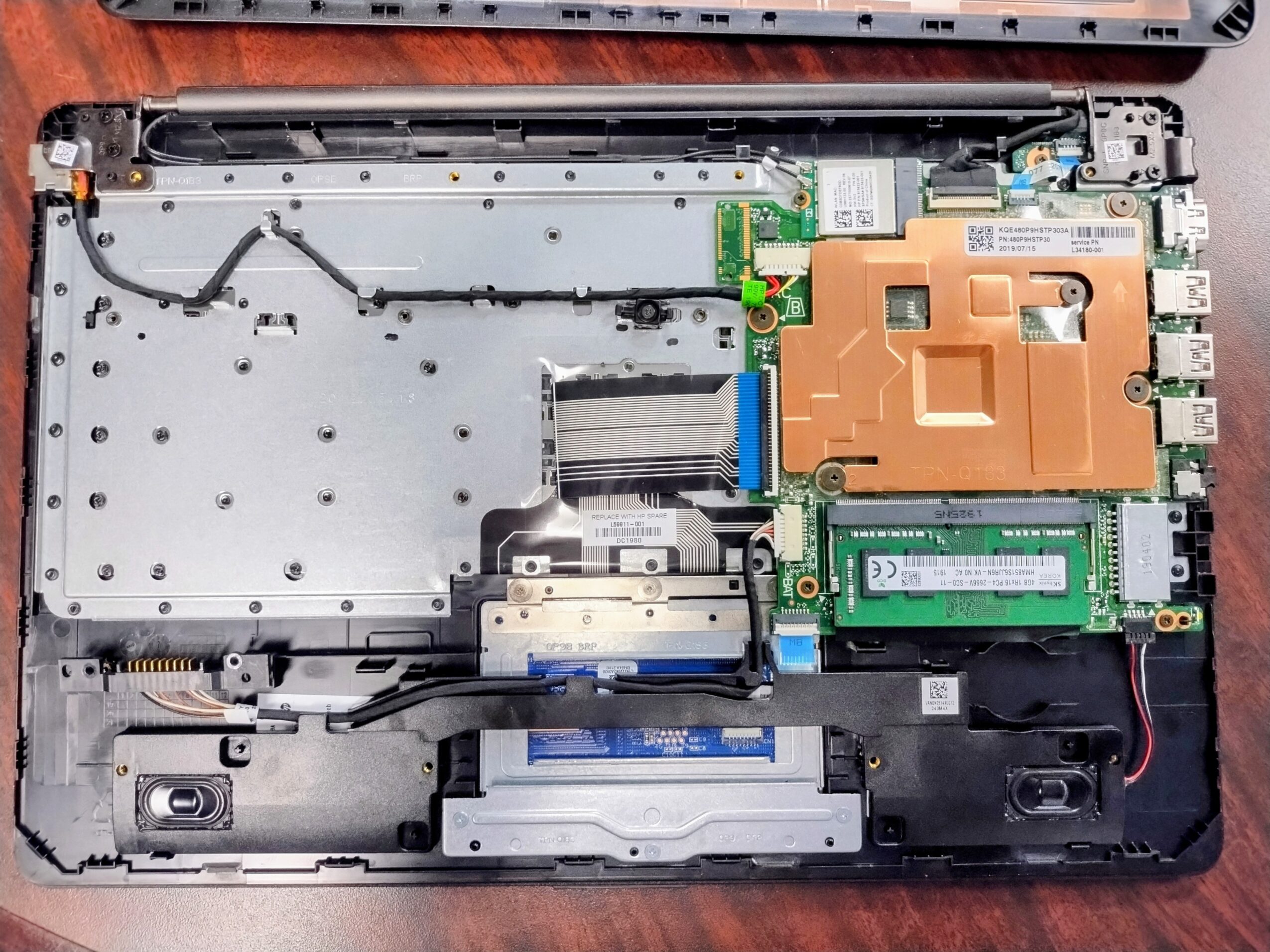 Open laptop with internal components visible, including cooling system, RAM, and circuit boards.