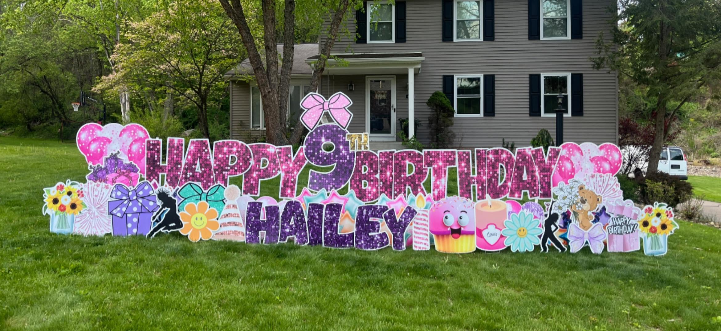 Colorful birthday display with flowers, bows, and a house in the background, celebrating Hailey's birthday outdoors.