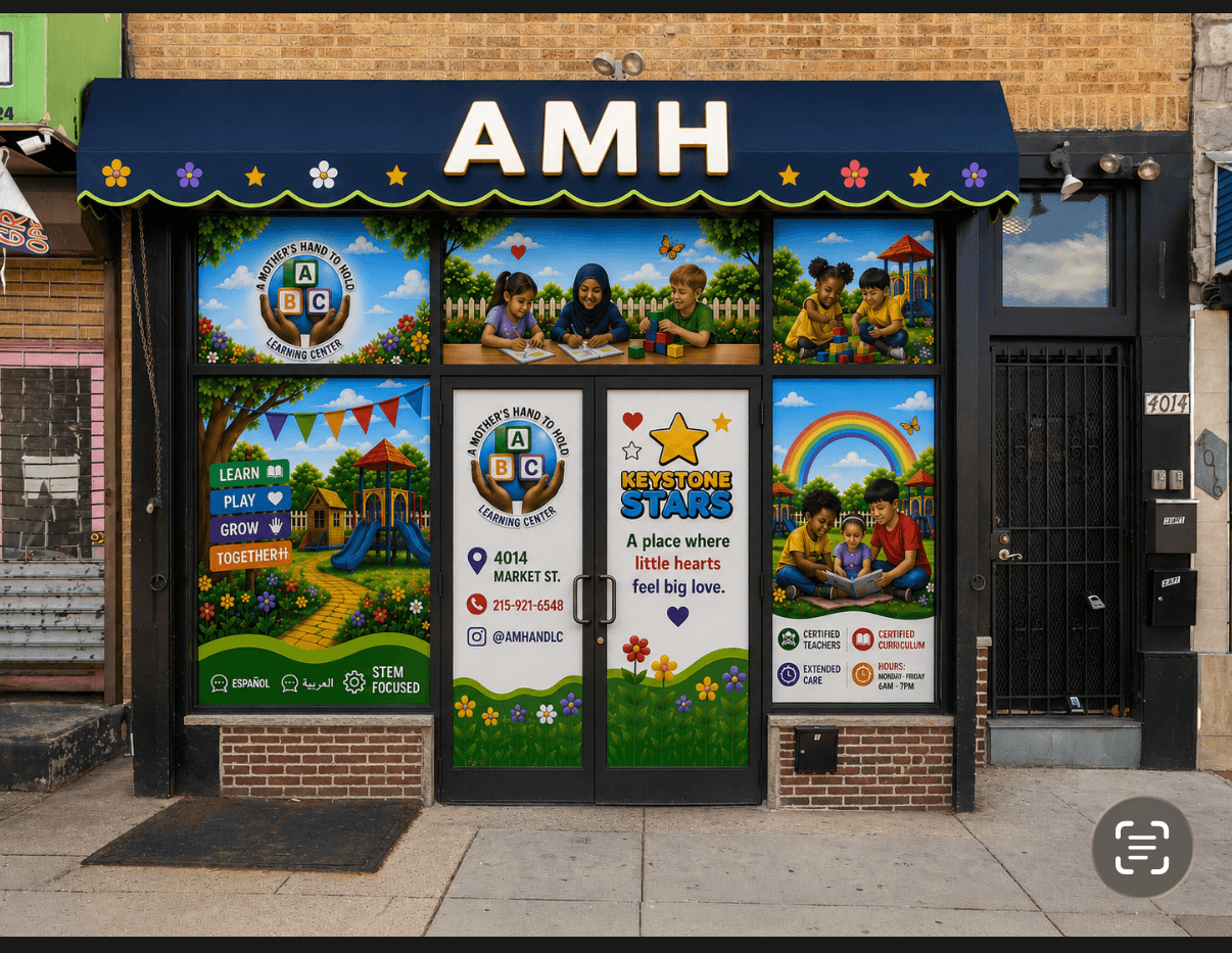 Storefront with AMH sign, colorful window displays with children, trees, rainbow, and educational graphics, brick and black exterior, sidewalk in front.