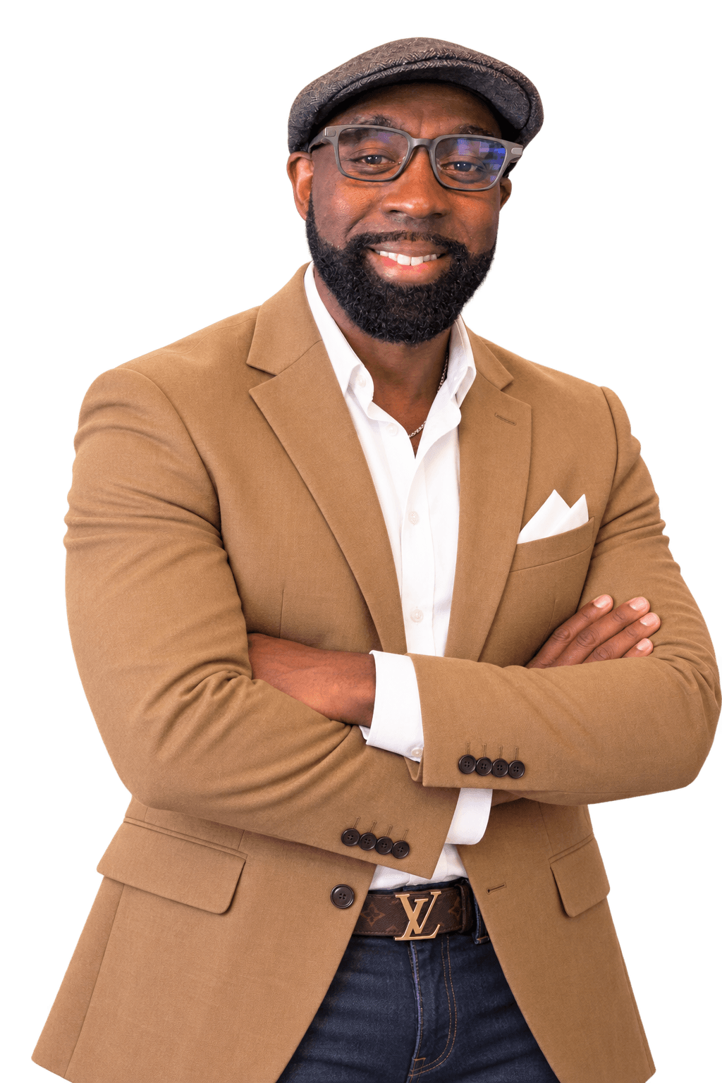 Man with glasses, beard, and hat smiling, wearing a tan blazer and white shirt, arms crossed.