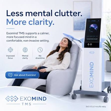 Woman relaxing in a chair with a device beside her, promoting mental clarity and focus, in a modern room.