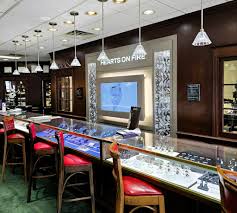 Bar area with chairs, a television, and pendant lights, with a sign reading 'Bar on Fire' on the wall.