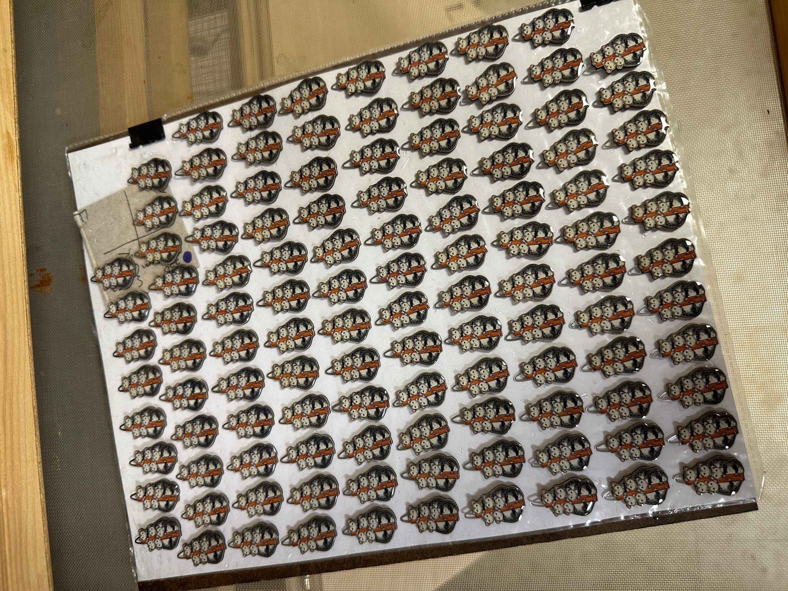 Sheet of stickers with multiple colorful ladybug designs, placed on a flat surface, viewed from the side.